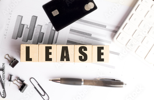 Lease concept with credit card, calculator, financial charts and office supplies representing leasing agreements, rental financing