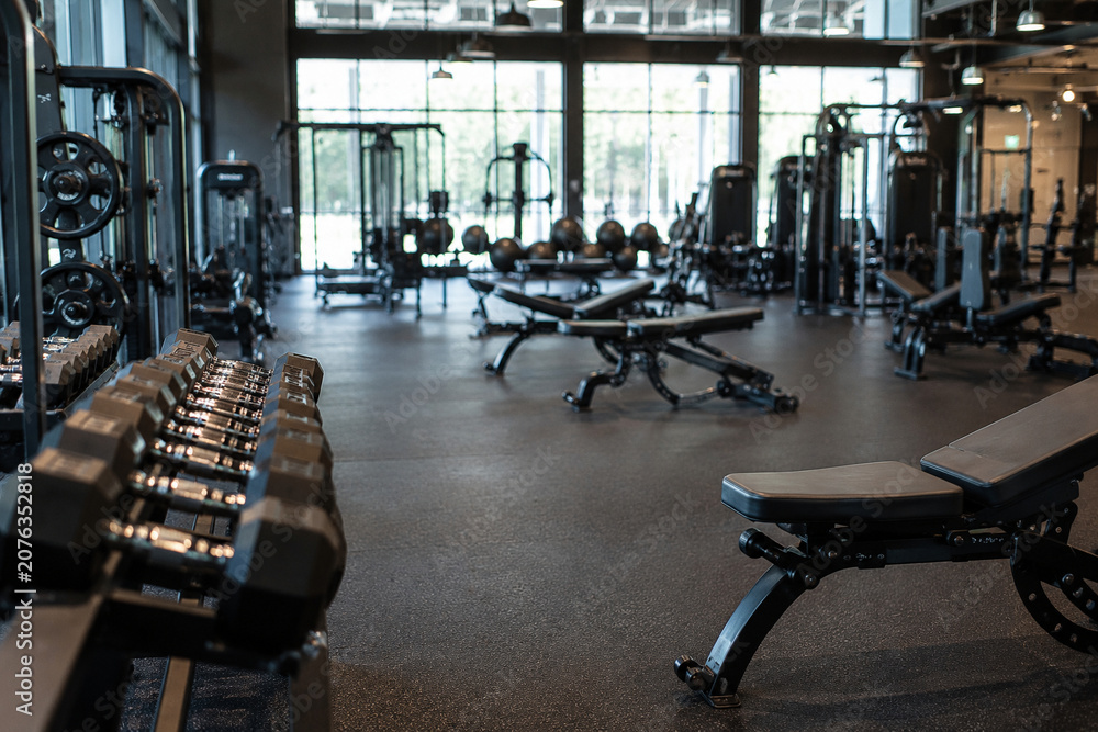 Fototapeta premium Modern Gym Interior Background with Fitness Equipment and Luxury Wellness Club Atmosphere