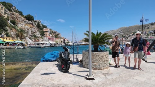 SYMI, GREECE - JUNE 5, 2026: Tourists walking through the colorful streets and harbor of Symi island during a sunny day