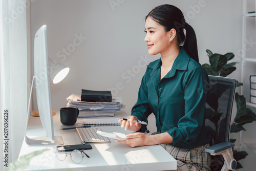 Asian Woman Working at Desk with Computer Calculator and Pen Acc