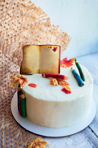 white cake with edible book decor