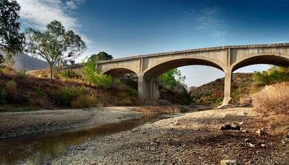 elevated concrete structure over a dry creek bed showing signs of age and weathering