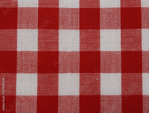Close up of classic red and white checkered fabric background. Texture of red gingham cotton cloth. 