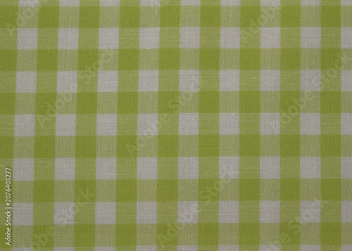 Texture of lime green and white gingham fabric background. Close up of classic green plaid cotton cloth. 