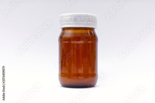 An empty amber glass medicine bottle with a white plastic cap, isolated on a white background, featuring a glossy blank surface ideal for pharmaceutical or supplement mockup branding