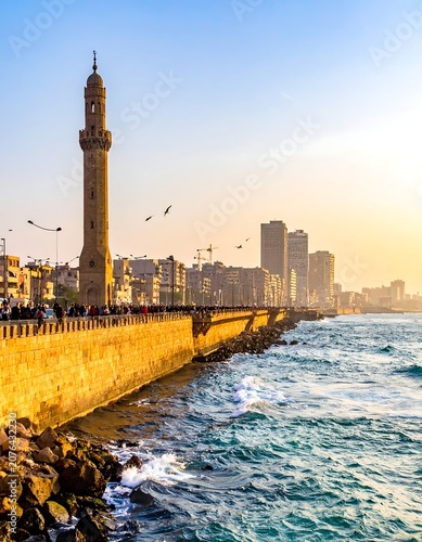 Golden hour view of historic mosque and city skyline.