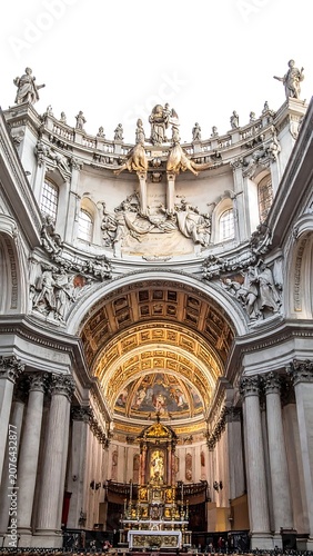 Grand interior of historic ornate cathedral with golden dome.
