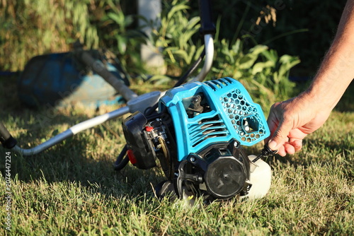 Checking the engine oil level with a dipstick on a 4-stroke grass trimmer