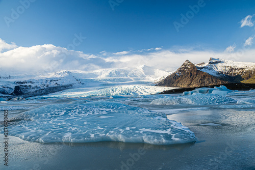 Obraz na płótnie Panoramic view of a frozen glacier lagoon with floating ice sheets and massive i