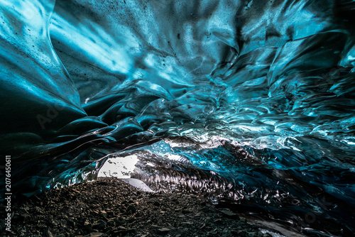 Beautiful blue ice cave interior with skylight hole opening to the sky in Vatnajökull National Park, Iceland