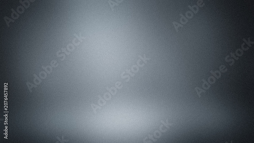 Abstract dark grey studio background with soft spotlight illumination.