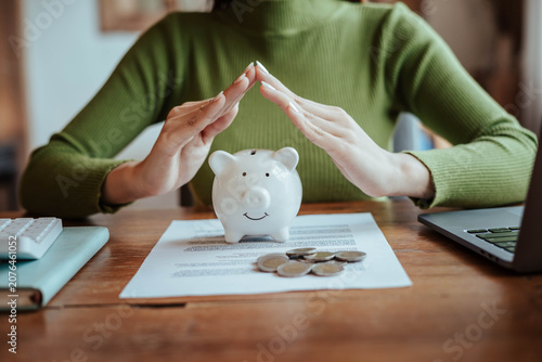 Protecting Savings with Piggy Bank and Hands in Financial Security Concept