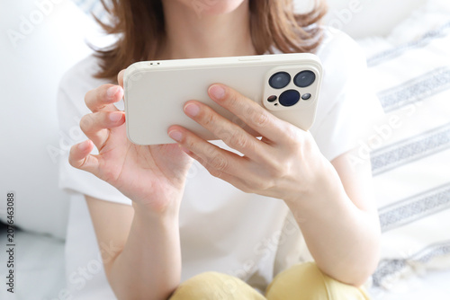 Schilderij op canvas 横向きでのスマートフォンを操作する女性