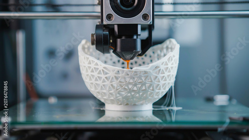 3d printer creating a white plastic object in workshop