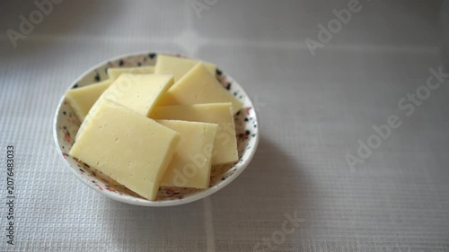 Sliced Hard Cheese Slices Laid Out Beautifully On Porcelain Breakfast Plate On Table With Linen Tablecloth