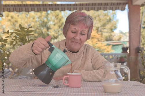 Mujer sonriente sirviendo café de una cafetera italiana