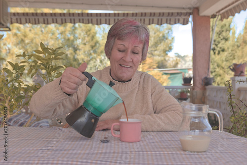 Mujer sonriente sirviendo café de una cafetera italiana
