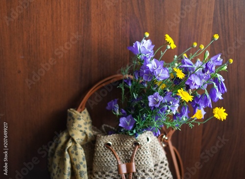 Canvastavla Close-up of a wicker straw summer bag with a blue bouquet of foxglove bells and