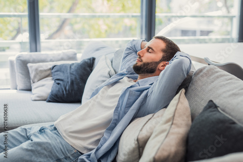 Foto Man with eyes closed experiencing comfort and relaxation, unwinding on a modern