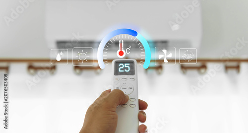 Quadro su tela The air conditioner remote is in hand, and a button is pressed to select the different modes