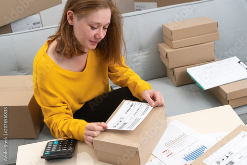 Foto Woman putting shipping label on cardboard box working in her small business star