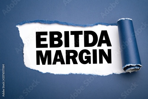Ebitda margin corporate financial text visible under torn blue paper