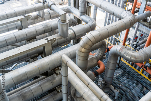 Intricate industrial metal pipeline system inside a factory facility