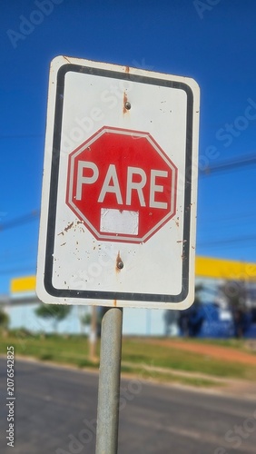 Brazilian traffic stop sign on a metal pole against a bright blue background