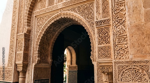 Intricate Arabian archway with detailed geometric carvings and Arabic calligraphy
