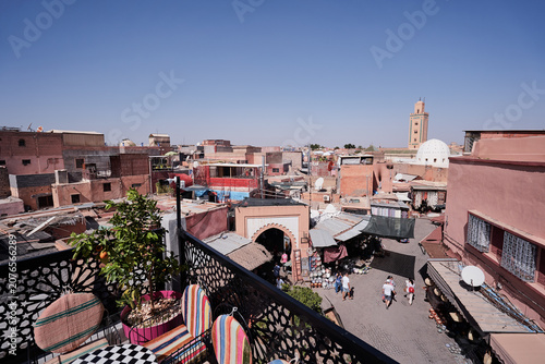 Obraz na plátně A rooftop view of a bustling Moroccan market with traditional architecture and a mosque in the background under a clear blue sky