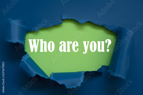 Who Are You Question Revealed Through Torn blue Paper On Lime Green Background For Identity Self Discovery And Personal Growth Concept