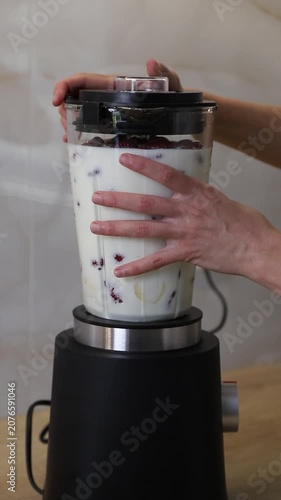 Preparing a delicious fruit milkshake in a blender