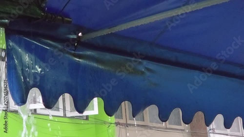 Rainwater Draining from a Blue Awning