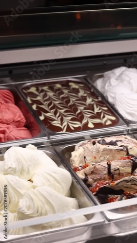 Supermarket ice cream shelf with various flavors and brands, retail food concept.