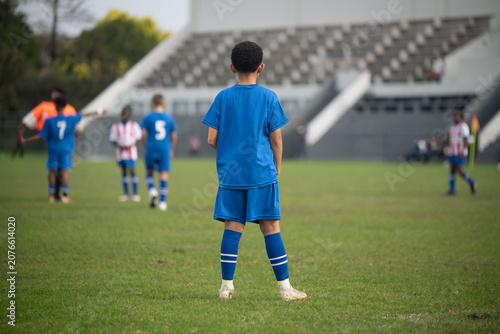 Young soccer player seen standing on the field