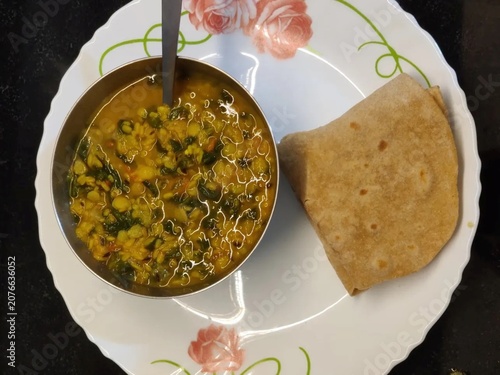Traditional homemade Indian meal featuring wholesome lentil curry with whole wheat chapati, served on a clean plate. A nourishing vegetarian comfort food concept highlighting authentic flavors, simpli