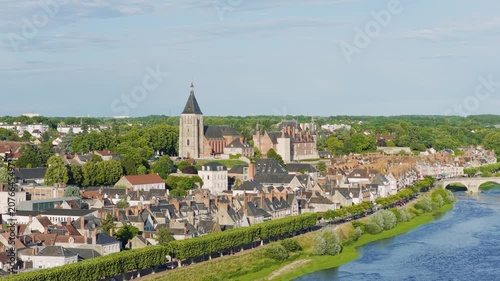 Aerial panoramic view of the historic town of Gien in the Centre-Val de Loire region of France, featuring traditional French architecture, the prominent Gien church, and the scenic Loire River with