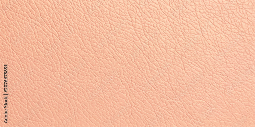 Fototapeta premium Close-up macro shot of the natural textured grain of light peach leather, showcasing its fine pores and subtle sheen. A luxurious, soft, and organic material perfect for fashion and interior design.