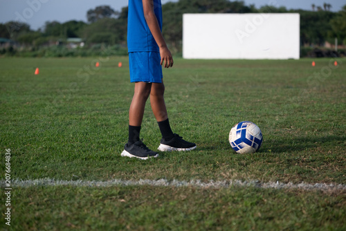Young boy with soccer ball on field