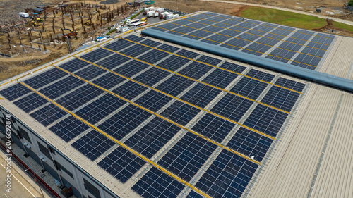 Fotografie Rooftop Solar Panels on Industrial Warehouse