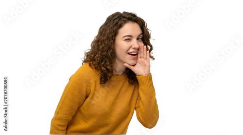 Cheerful young woman winking and whispering a secret on transparent background
