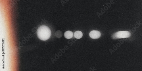 Photos Blurred circular shapes silhouette against black grainy photographic texture for