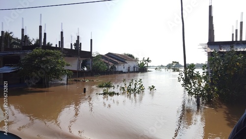 Foto Severe flooding submerging residential houses in a rural village landscape
