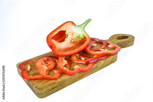 Obraz na płótnie Red bell pepper slices arranged on long wooden board