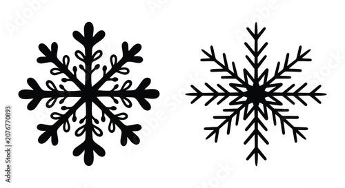 Vászonkép Two black snowflake silhouettes against a white background showcasing intricate