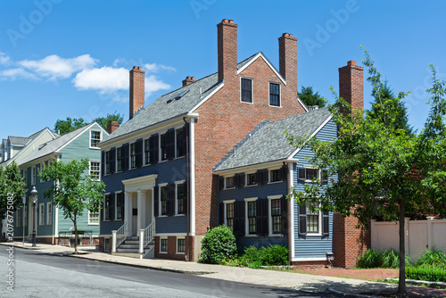 Historic blue clapboard house with multiple brick chimneys in direct sunlight, Charlestown, Boston
