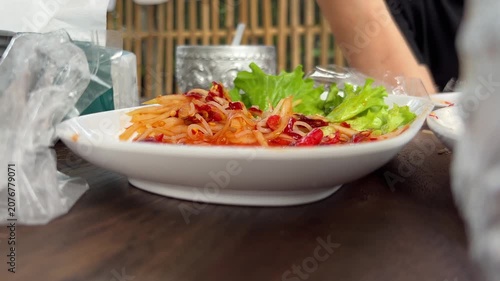 Close up shot person eating spicy papaya salad on plate