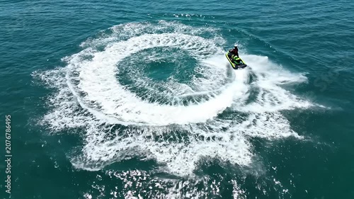 Jet ski carving white wake in blue ocean water