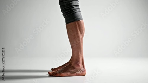 Close-Up Side Profile of Older Adult's Legs in Gray Fabric on Clean Studio Background for Health and Lifestyle Concepts