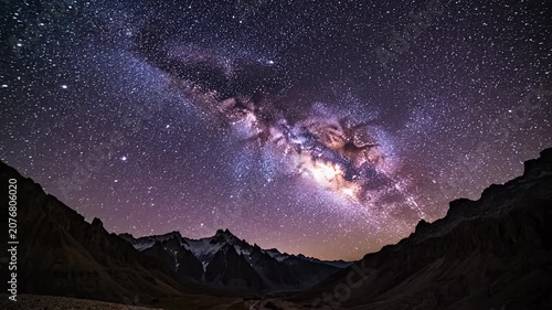 Milky Way galaxy stars over dark mountain peaks.